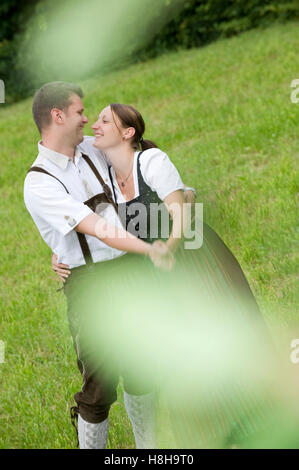Junges Paar in Tracht auf einer Wiese Stockfoto