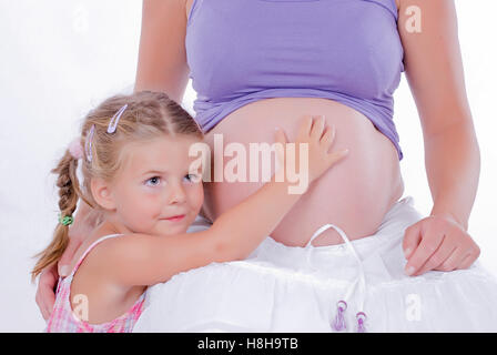 Mädchen, 4 Jahre alt, berührt Mutter-Baby-Bauch Stockfoto