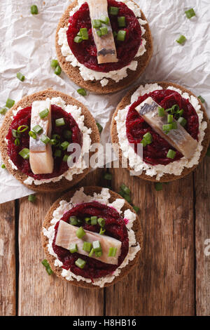 Norwegische Sandwiches mit Hering, rote Beete und Frischkäse auf dem Tisch. vertikale Ansicht von oben Stockfoto