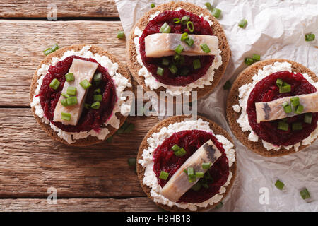 Norwegische Sandwiches mit Hering, rote Beete und Frischkäse auf dem Tisch. horizontale Ansicht von oben Stockfoto