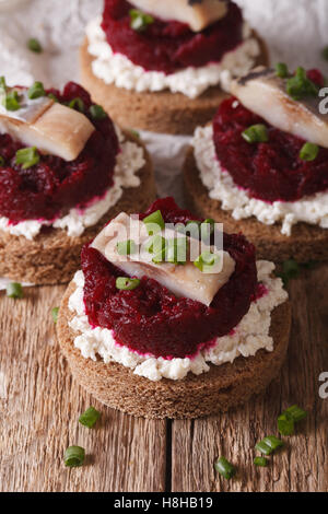 Norwegische Sandwiches mit Hering, rote Beete und Frischkäse auf einem Tisch-Makro. vertikale Stockfoto