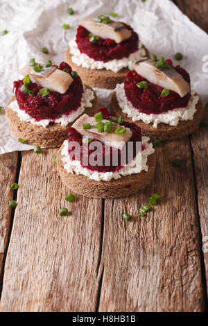 Leckere Sandwiches mit Hering, rote Beete und Frischkäse auf eine Tabelle Nahaufnahme. vertikale Stockfoto