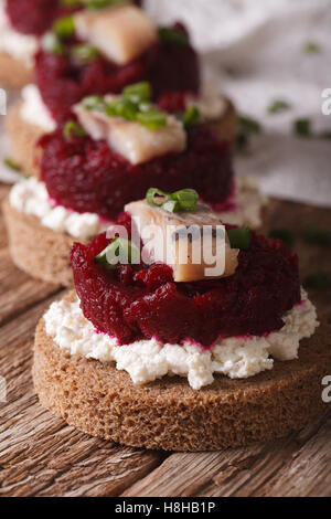 Sandwiches mit salzigen Hering, rote Beete und Hüttenkäse auf der Tabelle Nahaufnahme. Vertikal Stockfoto