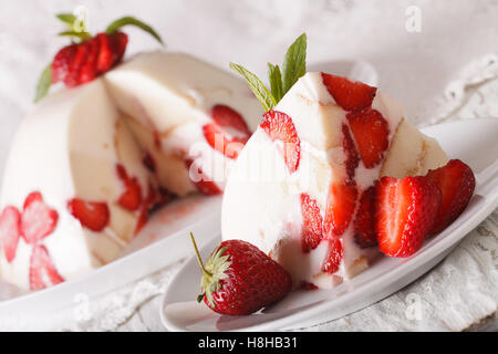Stück Käsekuchen mit frischen Erdbeeren und Biskuit Makro auf einem Teller. horizontale Stockfoto