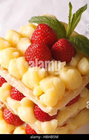 Leckere Erdbeere Millefeuille mit Vanillesauce, dekoriert mit Minze, close-up. vertikale Stockfoto