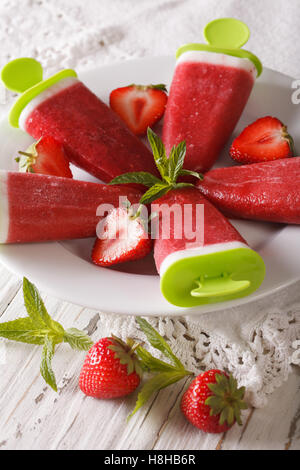 Erdbeer-Sorbet mit Joghurt und Minze auf eine Stick-Nahaufnahme auf einer Platte. vertikale Stockfoto