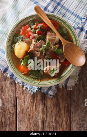 Shurpa-Lamm-Suppe mit Gemüse Closeup auf den Teller auf den Tisch. Vertikale Ansicht von oben Stockfoto