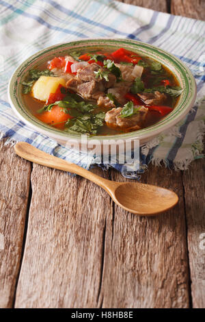 Shurpa-Lamm-Suppe mit Gemüse Closeup auf den Teller auf den Tisch. vertikale Stockfoto