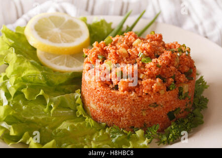 Türkischer Salat aus Bulgur Kisir Nahaufnahme auf einer Platte. horizontale Stockfoto