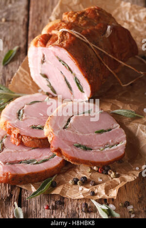 Gebackene Roll vom Schwein gefüllt mit Salbei hautnah auf dem Tisch. Vertikal Stockfoto