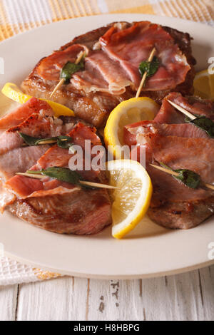 Italienisches Rindfleisch Saltimbocca mit Salbei, Schinken und Zitrone Nahaufnahme auf einer Platte. Vertikal Stockfoto