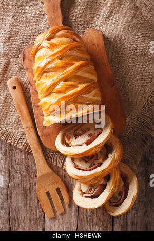 geschnittenes Brot gefüllt mit Schinken und Oliven Nahaufnahme auf dem Tisch. Vertikale Ansicht von oben Stockfoto