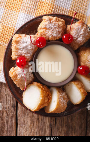 Gebratene Milch Dessert mit Kondensmilch Nahaufnahme auf einer Platte. vertikale Ansicht von oben Stockfoto