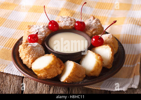 Dessert Leche Frita und Kondensmilch, dekoriert mit Kirschen Nahaufnahme auf einer Platte. horizontale Stockfoto