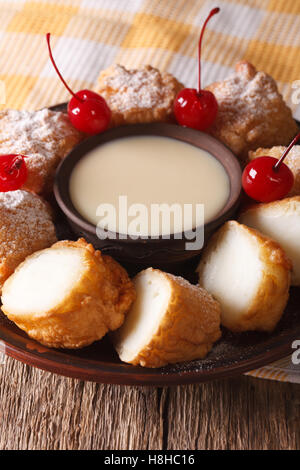 Gebratene Milch Dessert mit Kondensmilch Nahaufnahme auf einer Platte. Vertikal Stockfoto