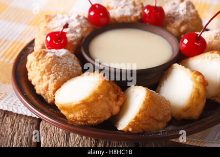 Dessert-Leche Frita mit Kondensmilch und Kirschen auf einer Platte-Nahaufnahme. horizontale Stockfoto