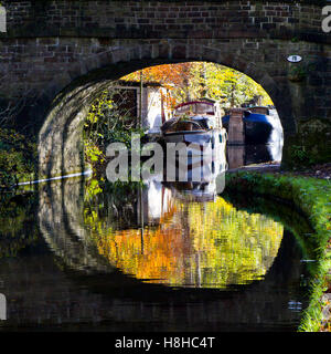 Eine Brücke spiegelt sich in den Rochdale Kanal im Herbst, in der Nähe von Hebden Bridge West Yorkshire England UK Stockfoto