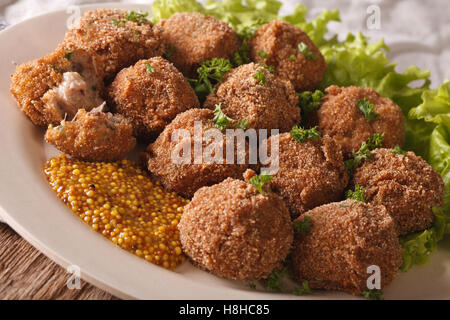 Holländische Fleischkroketten Bitterballen und Senf hautnah auf einem Teller auf den Tisch. Horizontale Stockfoto