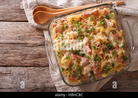 Österreichischen Nudeln überbacken mit Schinken und Parmesan Nahaufnahme in ein Glas Auflaufform auf den Tisch. horizontale Ansicht von oben Stockfoto