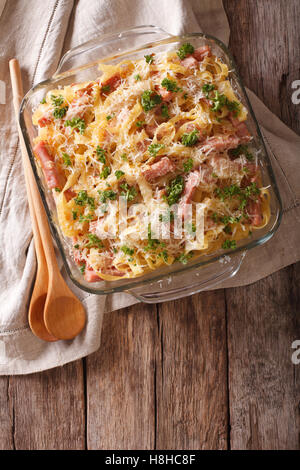 Österreichischen Nudeln überbacken mit Schinken und Parmesan Nahaufnahme in ein Glas Auflaufform auf den Tisch. Vertikale Ansicht von oben Stockfoto