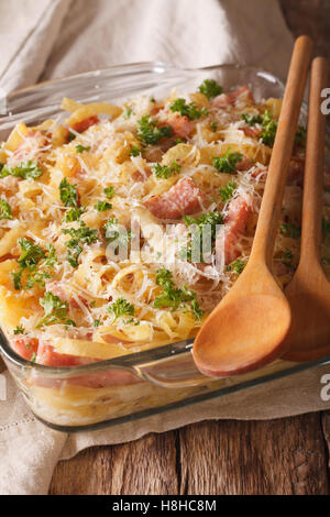 Österreichischen Nudeln überbacken mit Schinken und Parmesan Nahaufnahme in ein Glas Auflaufform auf den Tisch. Vertikal Stockfoto