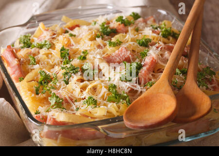 Österreichischen Nudeln überbacken mit Schinken und Parmesan Nahaufnahme in ein Glas Auflaufform auf den Tisch. horizontale Stockfoto