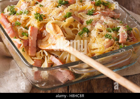 Österreichische Küche: Schinkenfleckerln Makro in Auflaufform auf den Tisch. Horizontale Stockfoto