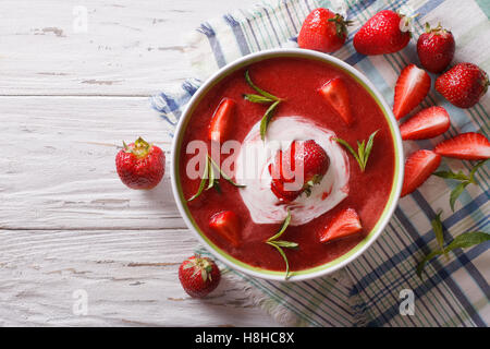 Süße kalte Erdbeer-Suppe mit Minze und saure Sahne in eine Schüssel Nahaufnahme. Horizontale Ansicht von oben Stockfoto