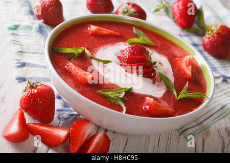 Köstliche Erdbeer-Suppe mit Sahne und Minze in einer Schüssel-Nahaufnahme. horizontale