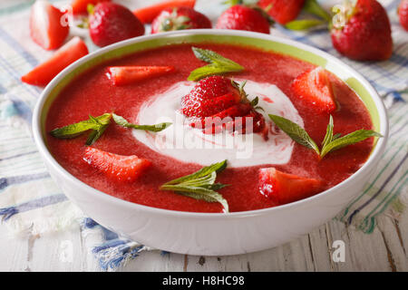 Süße kalte Erdbeer-Suppe mit Minze und saure Sahne in eine Schüssel Nahaufnahme. horizontale Stockfoto