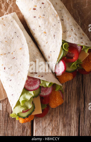 Tortilla Rollen mit Fingern, Käse und Gemüse Nahaufnahme Fisch auf den Tisch. vertikale Ansicht von oben Stockfoto