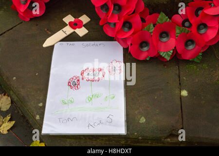 Hinweis für die gefallenen Soldaten aus einem 5 Jahre alten namens Tom am Stockton Heide Kenotaph mit Mohn Kränze platziert Stockfoto