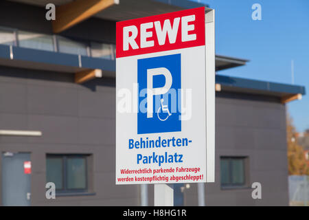 BURG / Deutschland - 13. November 2016: Behindertenparkplatz (Behindertenparkplatz) Zeichen auf dem Parkplatz vom Supermarkt REWE. Stockfoto