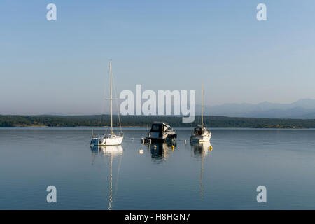 Drei kleine Boote / Yachten Achored in einer sicheren Bucht am Morgen, ruhige See Stockfoto