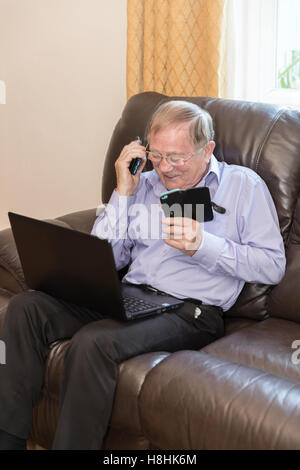 Vertikale Schuss der Rentner mit modernen elektronischen Geräten wie Laptop und Handy Stockfoto