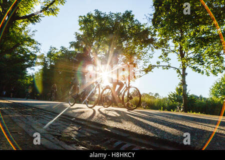 Radfahrer im Vondelpark in Amsterdam, Silhouette gegen die Sonne. Stockfoto