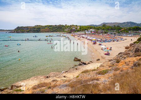 Touristen entspannen Sie am Strand von Agios Nikolaos, griechische Insel Zakynthos. Es ist ein beliebter Sandstrand in Vassilikos, Zakynthos, Griechenland Stockfoto