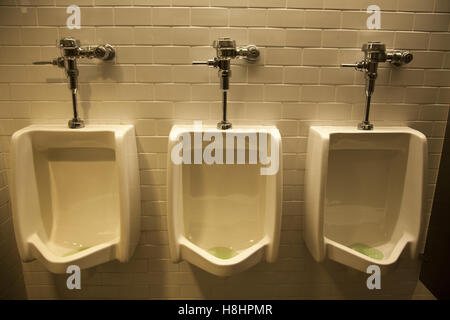 Urinale in einer öffentlichen Herrentoilette in New York City. Stockfoto