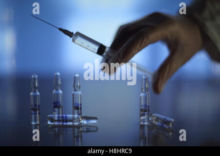 Medizinische Spritze und Fläschchen auf Tisch im Krankenhaus Stockfoto