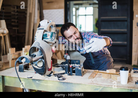 Zimmermann nimmt ein Selbstporträt mit Gehrung sah an seinem Arbeitsplatz Stockfoto