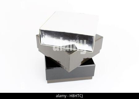 Stapeln von drei Büchern, vertikal. Silber, grau und schwarz mit weißem Hintergrund. Stockfoto