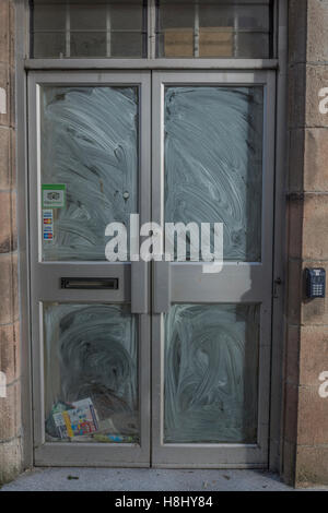 Closed Shop Räumlichkeiten - nicht abgeholte Post und Prospekte sammeln hinter Schaufenster. Tod von der High Street Metapher. Stockfoto