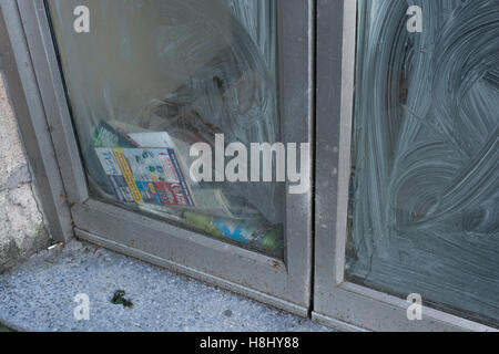 Closed Shop Räumlichkeiten - nicht abgeholte Post und Prospekte sammeln hinter Schaufenster. Tod von der High Street Metapher. Stockfoto