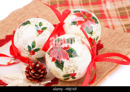 Bunte Weihnachtskugeln mit Bändern und Kegel auf Leinwand Hintergrund. Stockfoto