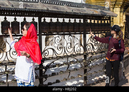 Besucher drehen die Gebetsmühlen in Swayambunath Stupa (Affentempel) Nepal, Kathmandu, Stockfoto