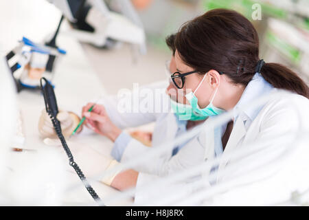 Beschäftigt junge Zahnmedizin-Studenten, die Arbeiten sorgfältig auf anatomische Modelle Stockfoto