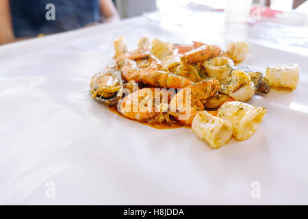 Krustentier Meeresfrüchte mit Muscheln, Austern und Garnelen am Tisch und weiß Wachspapier, Tiefenschärfe, Essen Hintergrund. Stockfoto