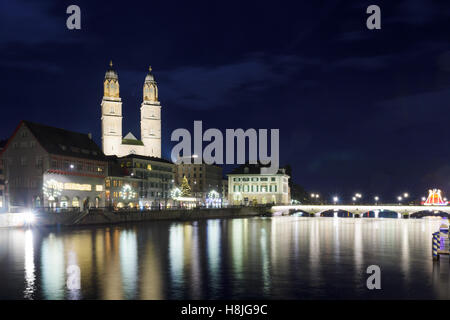 Blick auf das Grossmünster (Großmünster) Kirche und der Limmat in der Nacht, mit einem Weihnachtsbaum, in Zürich, Schweiz Stockfoto