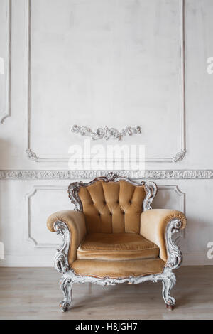 Wohnzimmer mit antiken stilvolle Beige Sessel auf Luxus weiße Wand Basrelief Stuck Zierleisten-Jahrgang Designelemente Stockfoto