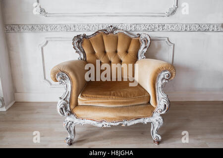 Wohnzimmer mit antiken stilvolle Beige Sessel auf Luxus weiße Wand Basrelief Stuck Zierleisten-Jahrgang Designelemente Stockfoto